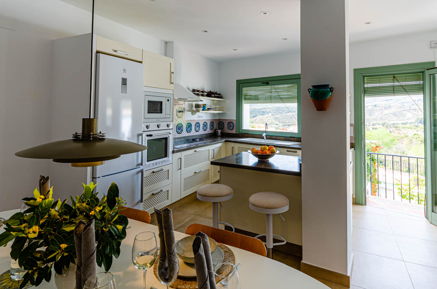 Dining area and kitchen with doors to terraces and annexe